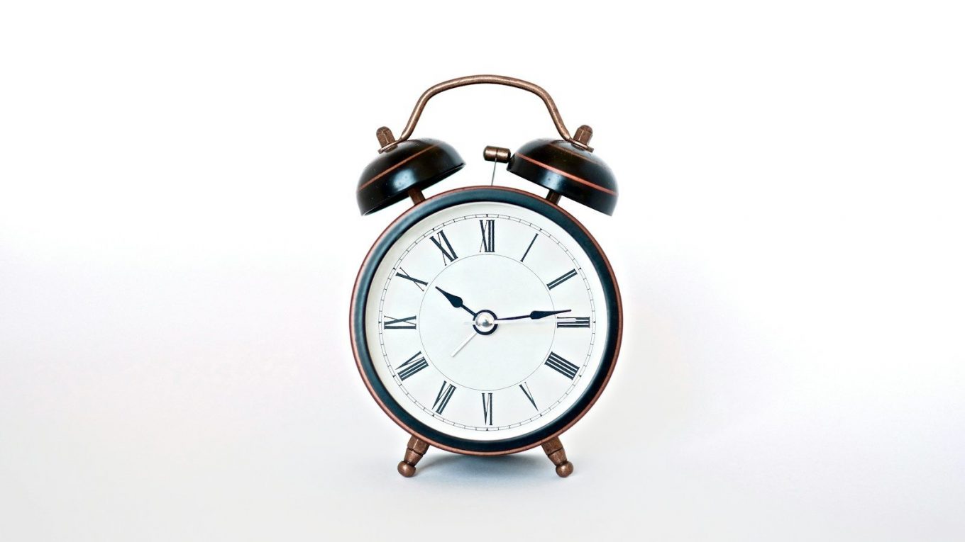 round black and white analog alarm clock